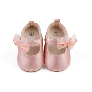 Primer plano de zapatos de bebé en rosa metalizado con un elegante lazo de tul suave