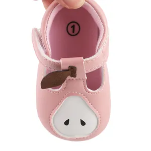 Primer plano detallado de zapatos rosas para bebé con diseño de pera y cierre de velcro
