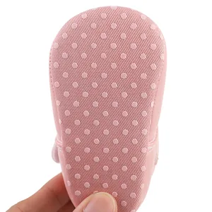 Vista detallada de la suela rosa antideslizante con lunares para zapatos de bebé