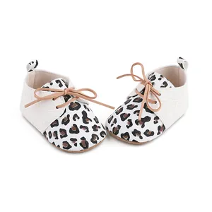 Close-up of leopard print baby walking shoes with white snakeskin texture and tan laces