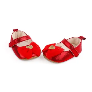 Close-up of red infant girl Mary Jane shoes with mesh bow and golden heart decoration
