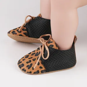 Macro detail of leopard print baby walking shoes featuring black textured faux leather