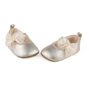 Detailed view of champagne gold baby princess shoes with polka dot tulle bows.