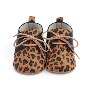 Detailed front view of leopard print baby walking shoes with black textured sides and tan bow