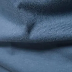 Nahaufnahme zeigt die weiche Baumwollstoffstruktur des blauen Henley-Shirts im Detail