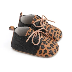Detailed view of infant walker shoes featuring stylish leopard print and black faux-crocodile texture