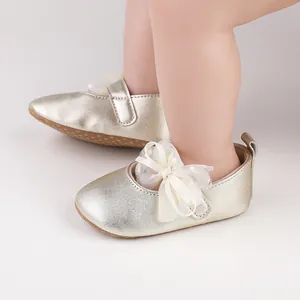 Primer plano de zapatos dorados para bebés con lazo decorativo de encaje para recién nacidos