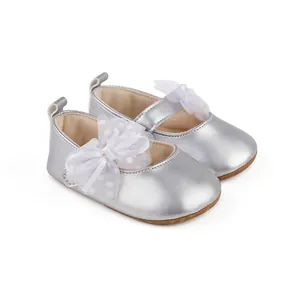 Detalle de zapatos plateados para bebé con lazo de malla blanca y forro muy suave.