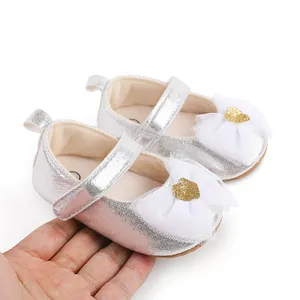Detail of silver baby girl princess dress shoes featuring a white lace bow and heart