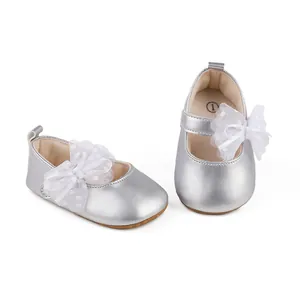 Detail of silver baby girl princess shoes with a decorative large white lace bow