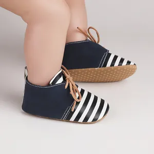 Detail of baby pre-walker shoes with navy blue suede and striped toe cap design