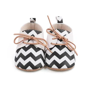 Front view detail of baby walking shoes featuring a stylish black and white chevron pattern