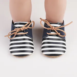 Close-up detail of striped infant walker shoes featuring navy blue accents and tan laces