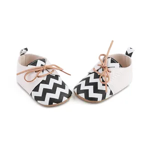 Detail view of baby walking shoes with black and white chevron pattern and laces