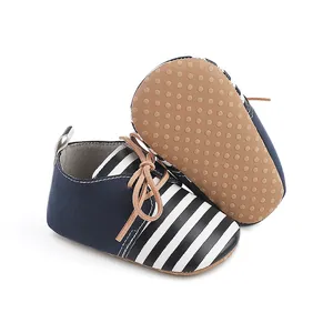 Detail view of navy blue striped baby walking shoes with anti-slip soft brown soles