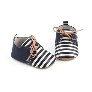 Detailed view of navy blue and white striped baby pre-walker shoes with tan laces