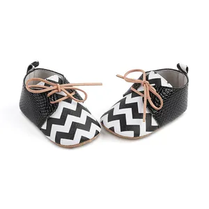 Close-up detail of baby boys' walking shoes with black and white chevron pattern
