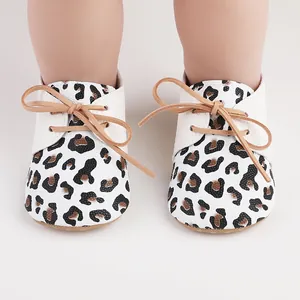 Close-up of leopard print baby walking shoes with tan laces and white texture