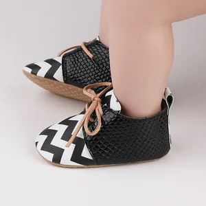 Detailed view of baby walking shoes with zigzag pattern and faux snakeskin texture