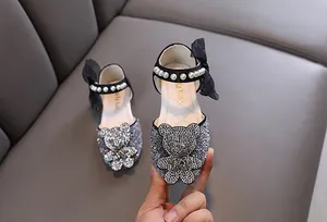 Gros plan de chaussures de princesse scintillantes pour filles avec ours en strass et perles