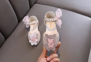 Gros plan de chaussures de princesse rose pour filles avec paillettes et motif d'ours
