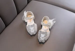Détail de chaussures de princesse brillantes pour filles avec ours en strass et brides en perles