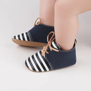 Close-up of navy blue and striped baby pre-walker shoes with soft anti-slip soles