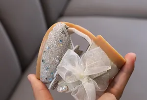 Détail de la semelle en caoutchouc souple et du nœud élégant en strass sur les chaussures fille