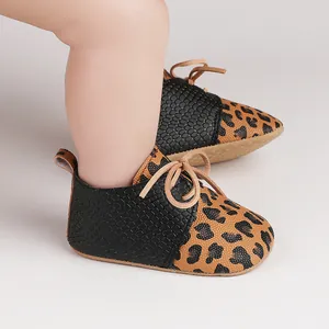 Detailed view of baby walker shoes featuring leopard and snake print with lace-up design