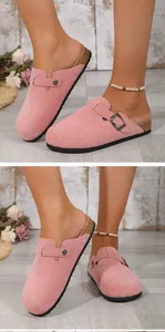 Detailed side view of pink suede clogs featuring adjustable metal buckle and cork sole.