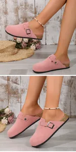 Close-up of pink suede closed-toe slippers with decorative buckle and cork sole