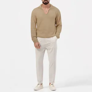 Vue complète d'un homme portant un polo en maille gaufrée kaki et un pantalon blanc.