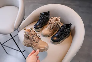 Close-up view of children's leather Martin boots featuring a side zipper design in two colors