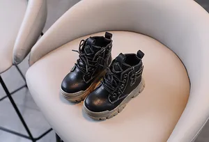 Close-up of children's black leather Martin boots with side zipper and white stitching