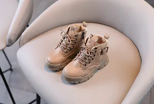 Detail view of stylish beige children's Martin boots with side zipper and metal buckle