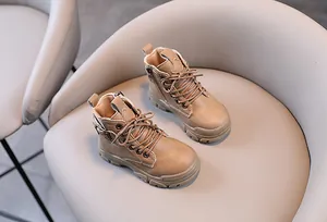 Detailed view of kids tan leather Martin boots with side zipper and lace-up design