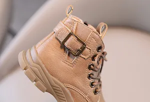 Close-up view of children's brown leather Martin boots featuring buckle and lace-up details.