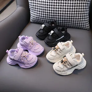 Detailed view of children's sneakers in multiple colors with cute bear charms.
