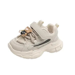 Detailed view of cream toddler dad sneakers with cute teddy bear ornament on laces