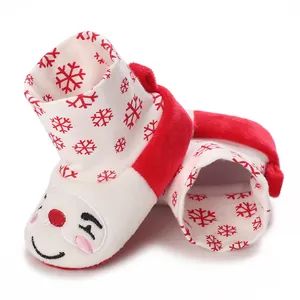 Primer plano de zapatos de invierno para bebé con bordado de muñeco de nieve y copos rojos