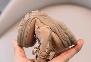 Close-up detail showing the soft and flexible rubber sole of brown children's boots