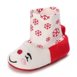 Detalle del bordado de muñeco de nieve en botas de invierno rojas y blancas para bebés.