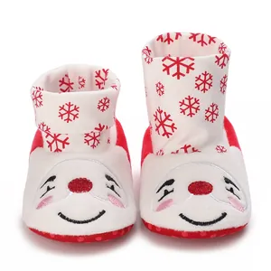 Detalle de zapatos de navidad para bebé con copos de nieve rojos y bordado de sonrisa