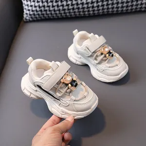 Children's chunky cream sneakers with cute bear charm and Velcro strap for toddlers walking.