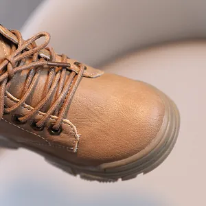 Close-up detail of children's brown leather Martin boots with round toe and laces