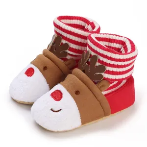 Close-up of cute reindeer-themed baby winter warm snow boots with red stripes