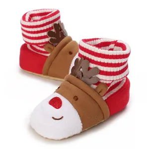 Nahaufnahme von Rentier-Babystiefeln mit rot-weiß gestreiftem Strickkragen für Winter.