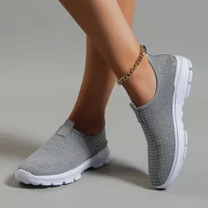 Primo piano di sneaker slip-on in maglia grigia traspirante con accenti di strass lucidi