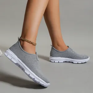 Dettaglio ravvicinato di sneaker slip-on in mesh grigio con strass scintillanti e suola