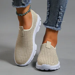 Primo piano di scarpe piatte slip-on in mesh Fly-knit beige traspiranti per l'estate